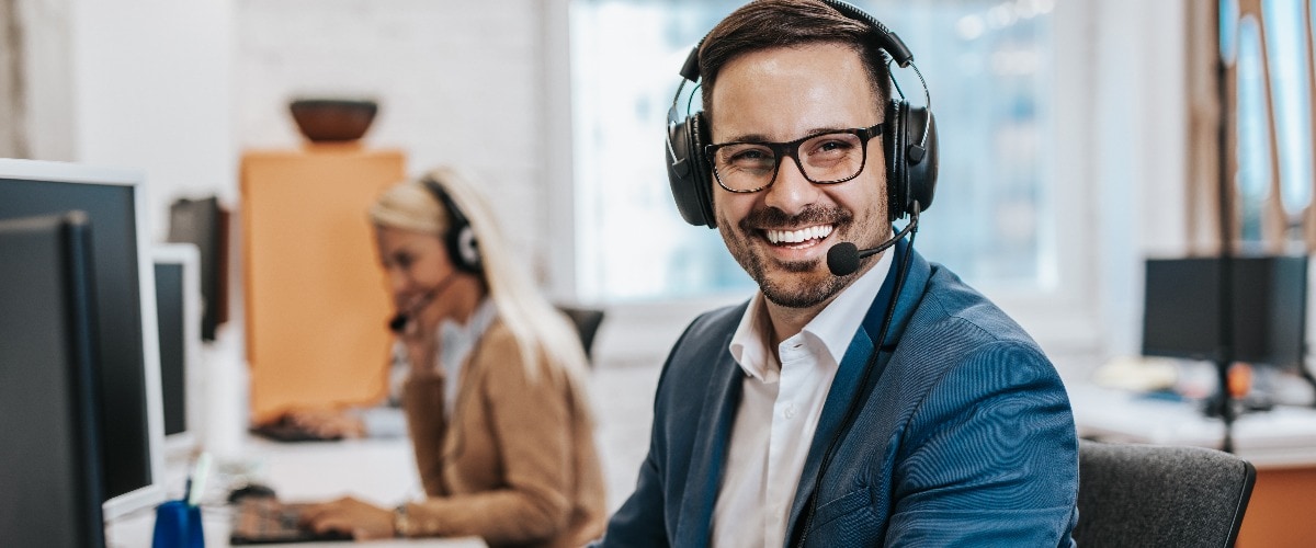 Glücklicher Mann arbeitet im Call Center in Essen