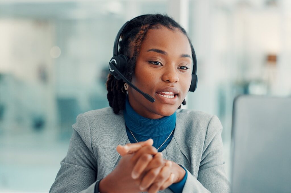 Callcentermitarbeiterin mit Headset in einem Beratungsgespräch